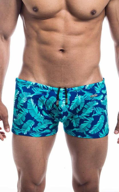 Oceanico square cut blue swim trunks with vibrant turquoise tropical leaf pattern perfect for beachwear