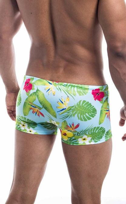 Oceanico square cut light blue swim trunks with vibrant tropical print of green leaves red yellow and white flowers