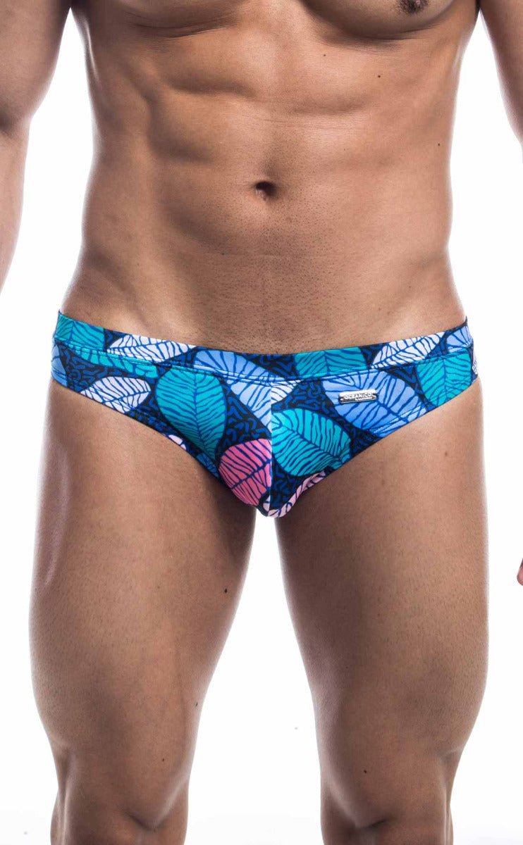 Blue and pink leaf-patterned men’s swim trunks with a vibrant tropical design from oceanico swim bikini collection