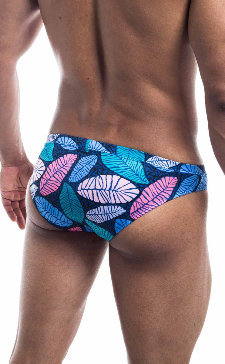 Oceanico swim bikini vibrant tropical leaf-patterned swim trunks in pink teal and white on dark blue base