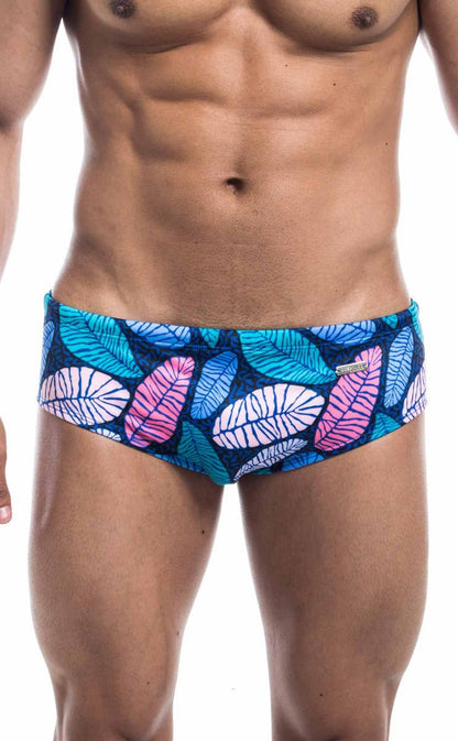 Oceanico swim brief featuring vibrant tropical leaf-patterned trunks in teal pink and white on dark blue base