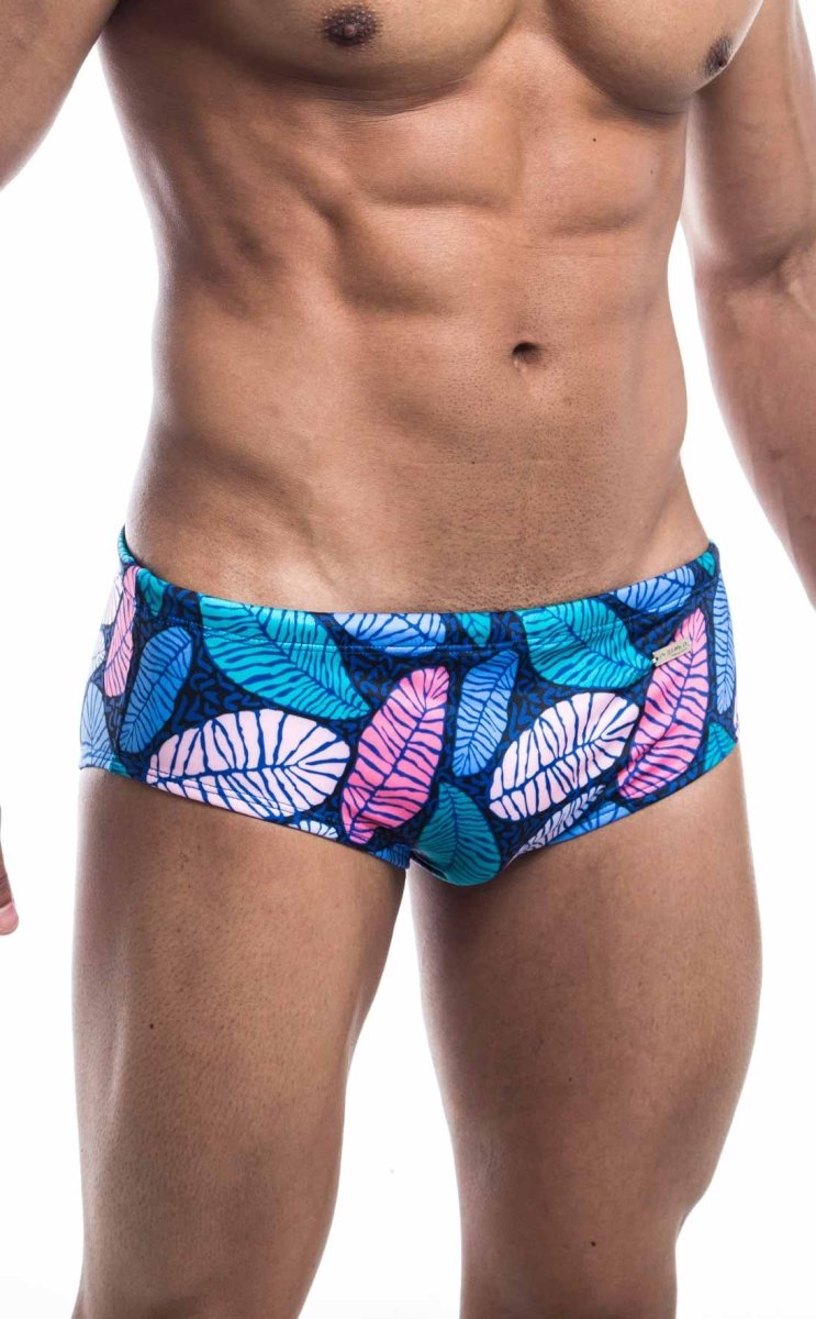 Oceanico swim brief featuring vibrant tropical leaf pattern in pink teal and white on dark blue swim fabric