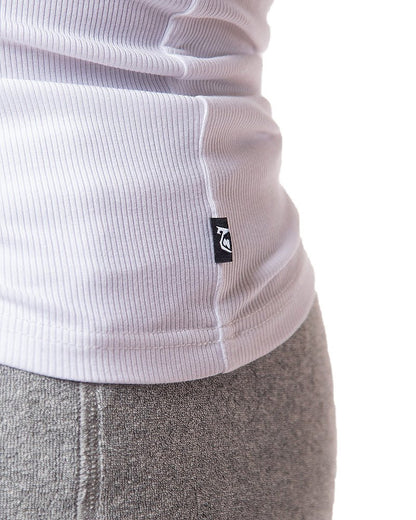 White ribbed knit pig rib tank top with small black logo tag at the hem