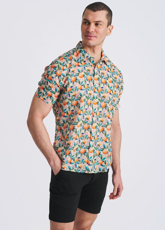 A short-sleeve button-down shirt with an orange and teal fruit and leaf print on a light background.