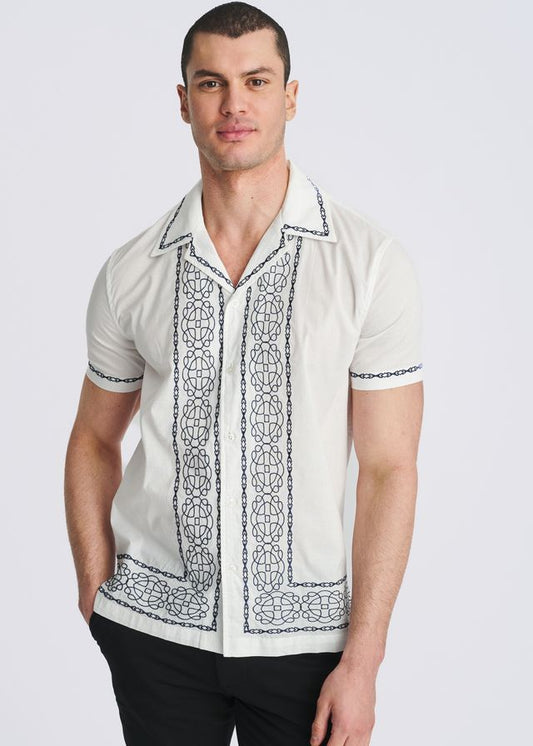 White short-sleeve button-down shirt with blue medallion embroidery framing the front placket, collar, and cuffs.