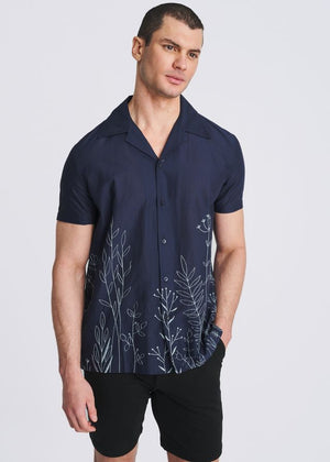 Navy short-sleeve button-down shirt with light blue embroidered floral and botanical border at the hem.