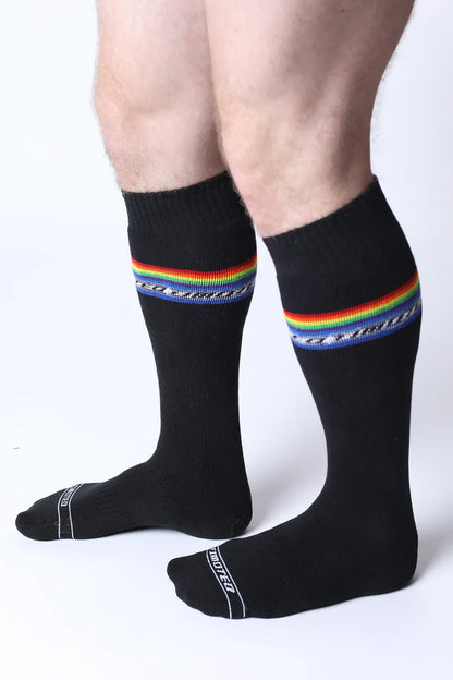 Black pride knee high socks with vibrant rainbow stripe, decorative blue pattern, and white text on the toe area