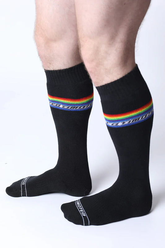 Black pride knee high socks with vibrant rainbow stripe, decorative blue pattern, and white text on the toe area