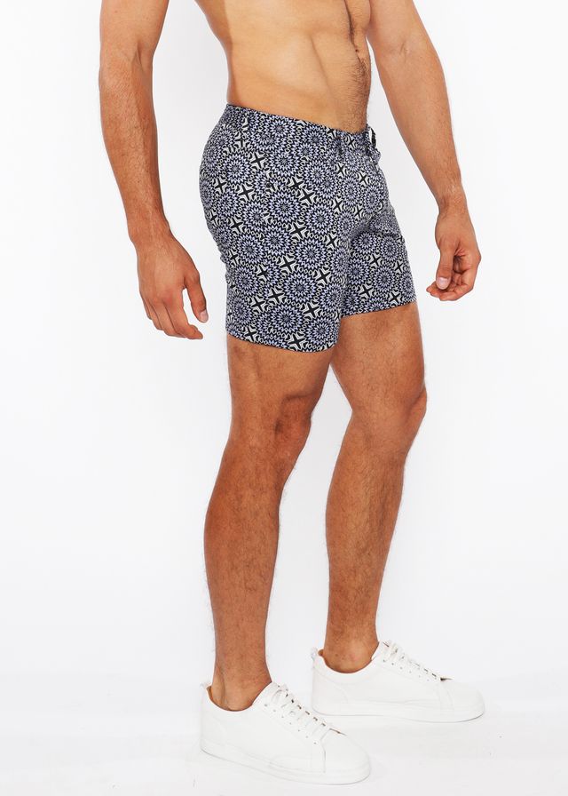 Printed stretch knit short swim trunks in blue and white geometric patterned fabric designed for comfort and style