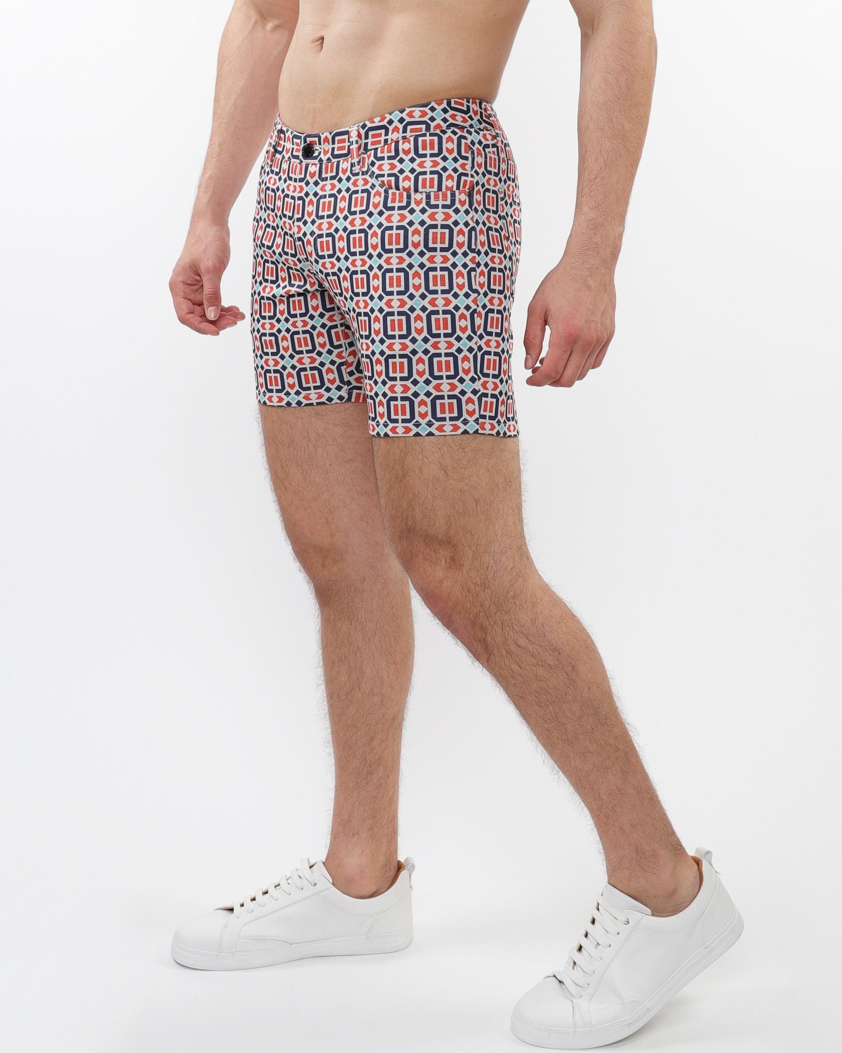Printed stretch knit shorts with bold red navy blue and white geometric pattern on a light background
