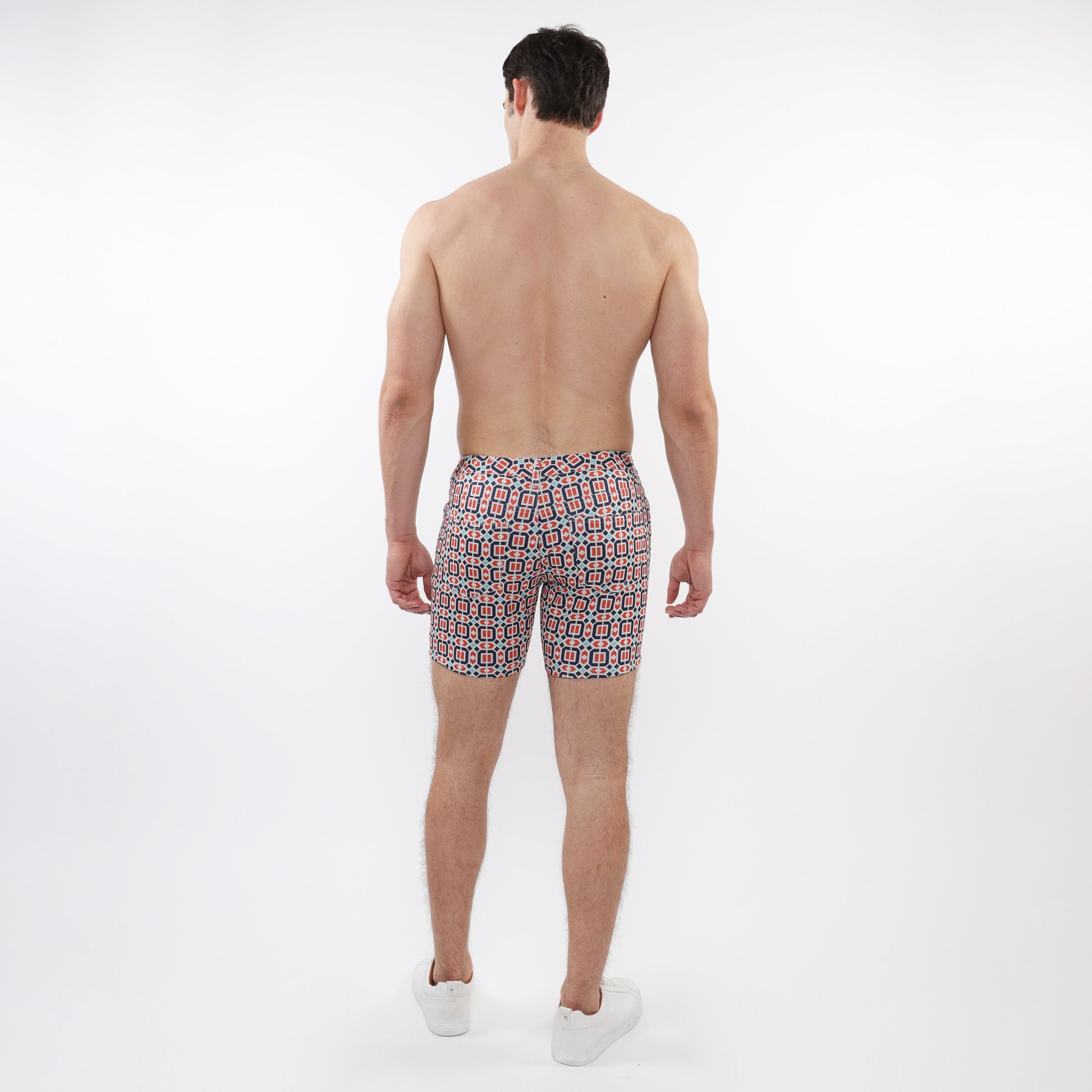 Men’s printed stretch knit shorts with a vibrant red black and white geometric pattern perfect for swimwear