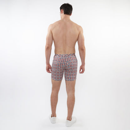 Men’s printed stretch knit shorts with a vibrant red black and white geometric pattern perfect for swimwear