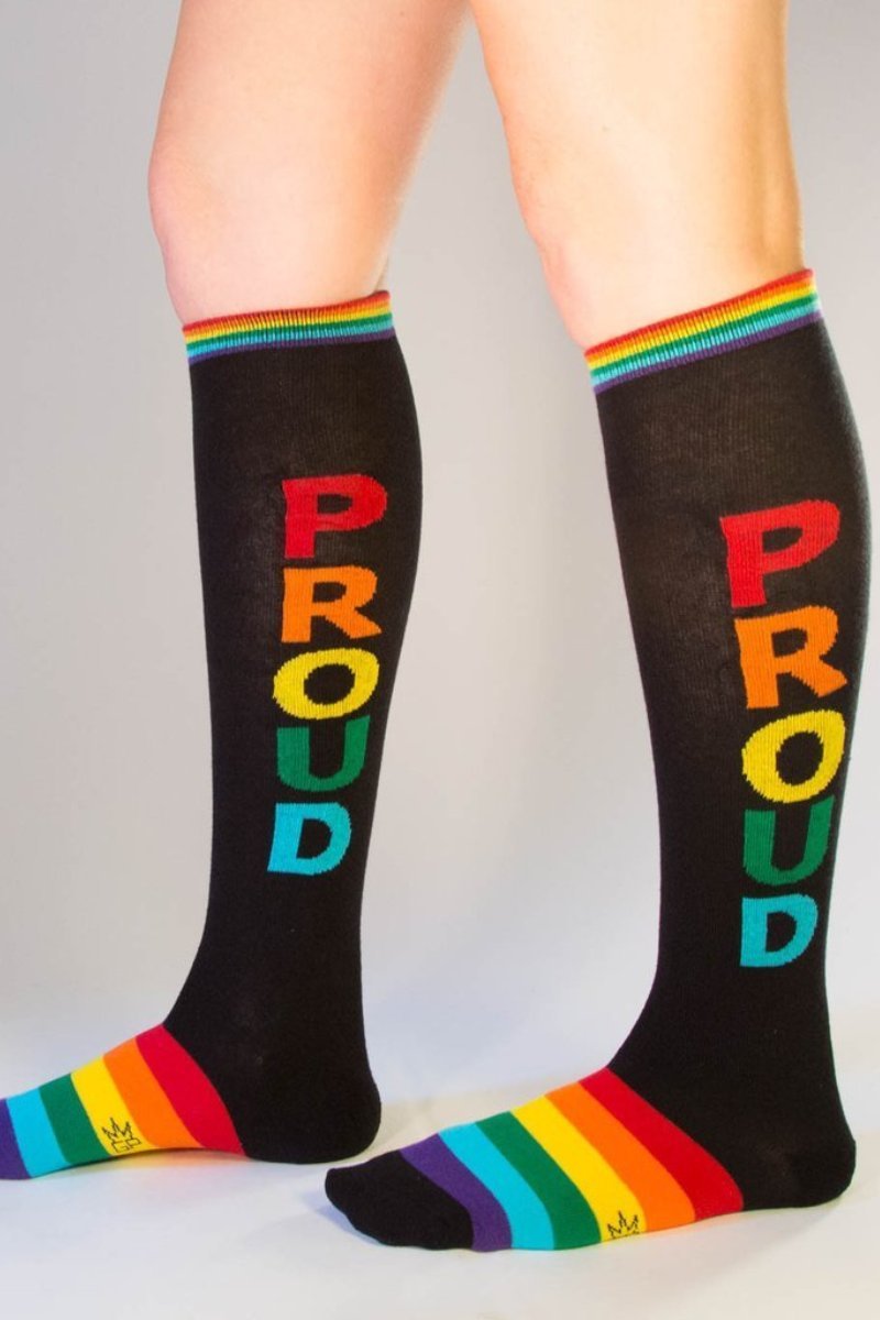 Black knee high socks with proud in rainbow letters and matching rainbow striped cuff and toe for pride wear