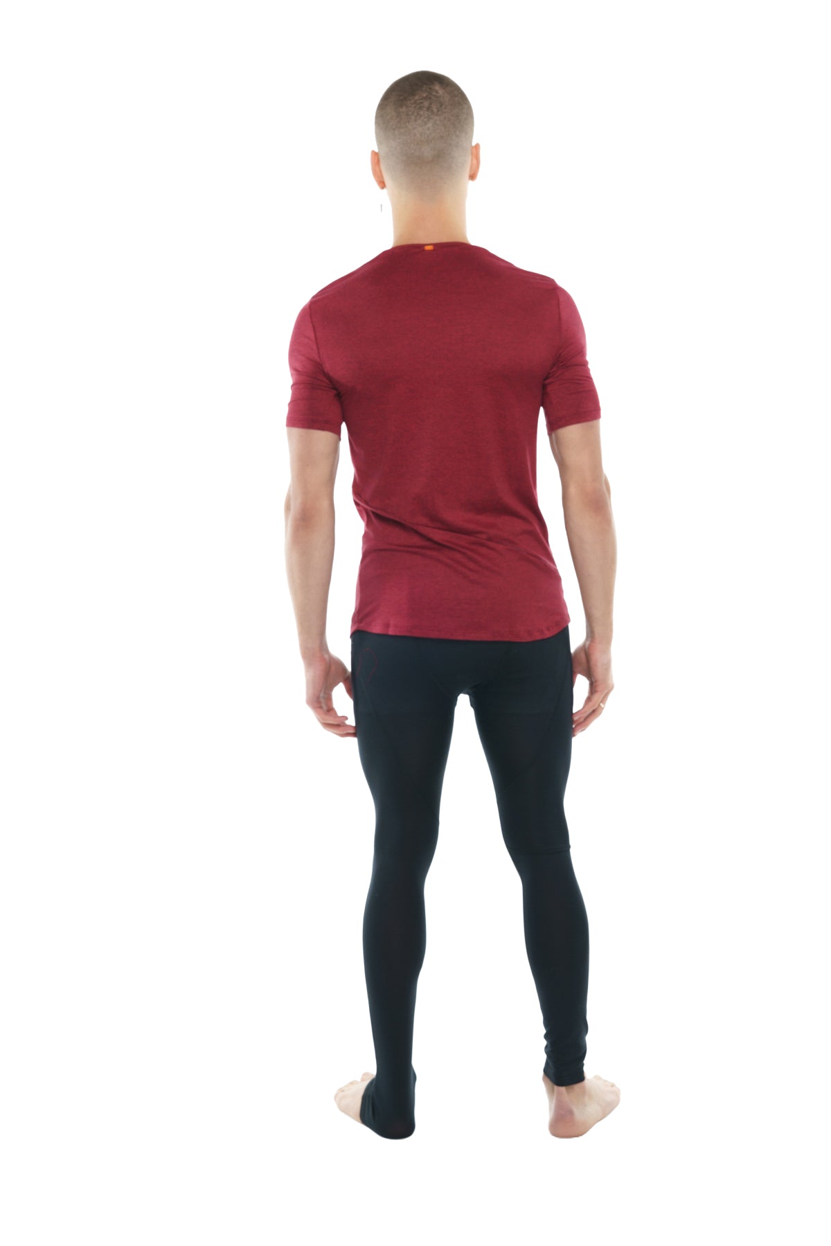 A man wearing a brick red heather perfect pocket crew-neck tee with black leggings showing the front side