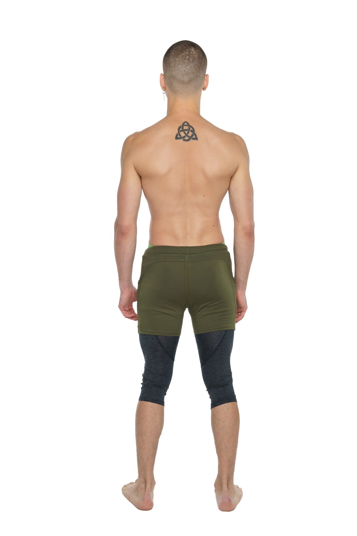 Olive green athletic shorts layered over black charcoal heather 3/4 performance yoga leggings for active wear