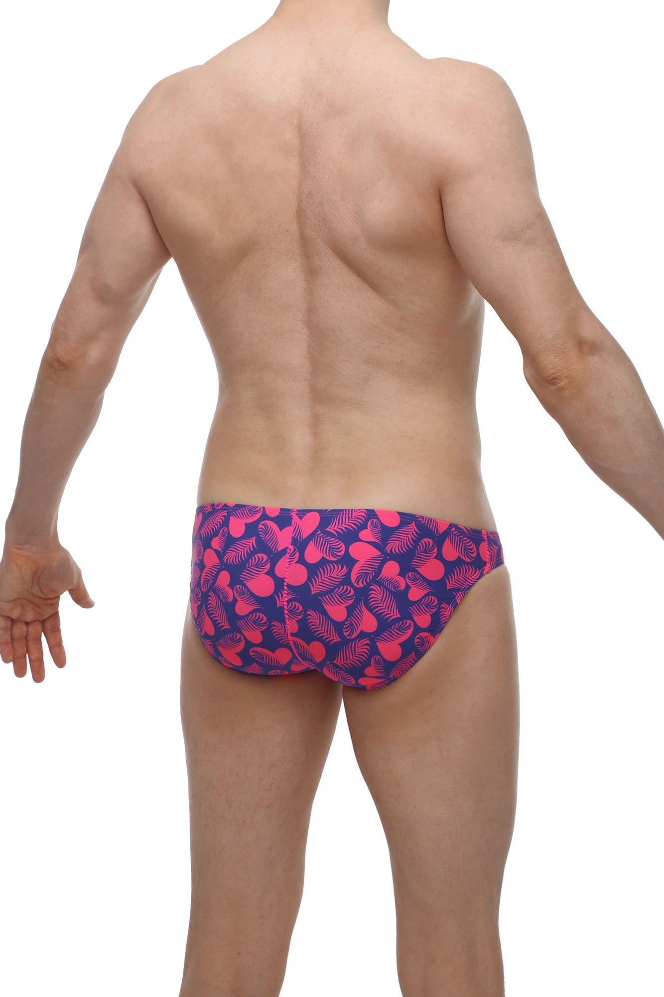 Vibrant pink and navy blue swim trunks with playful tropical leaf pattern from petitq bikini taik tropical hearts collection