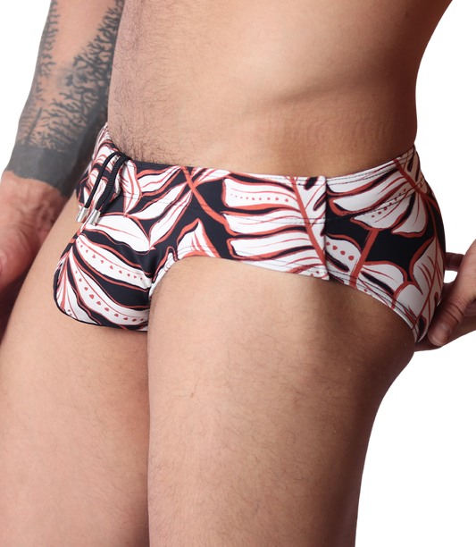 Side view of Gigo Prisma black swim brief featuring a white and red tropical leaf print and drawstring waist detail.