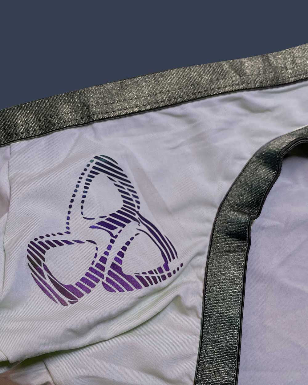 White fabric bare bikini underwear lilac with purple black striped abstract logo and shiny gray elastic waistband trim