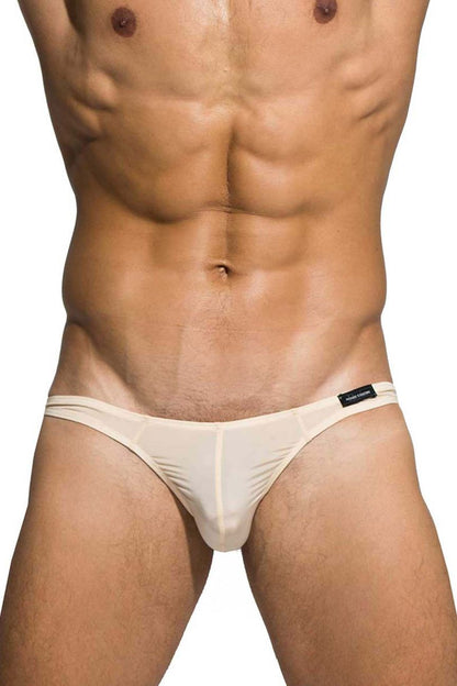 Cream-colored sheer mesh thong with subtle textured pattern and black brand tag on waistband nude private structure