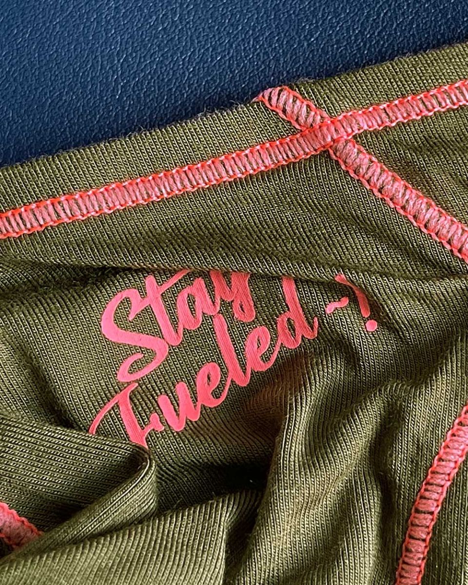 Olive green ribbed fabric prime eutopia bikini brief with pink embroidered text and matching pink stitching