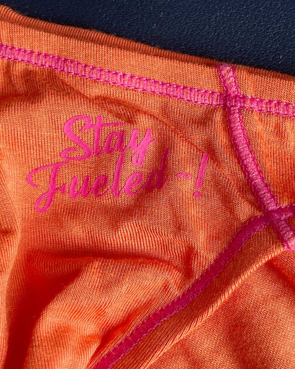 Orange athletic underwear with pink embroidered text and matching stitching private structure prime eutopia bikini brief