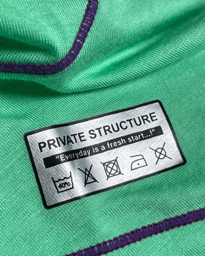 Green fabric with purple stitching and a silver private structure label showing care instructions on epus4570 hipster