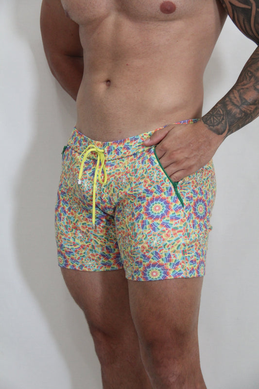 Rainbow kaleidoscope linen texture shorts featuring vibrant multicolored geometric swim trunks with neon yellow drawstring and green zipper accents