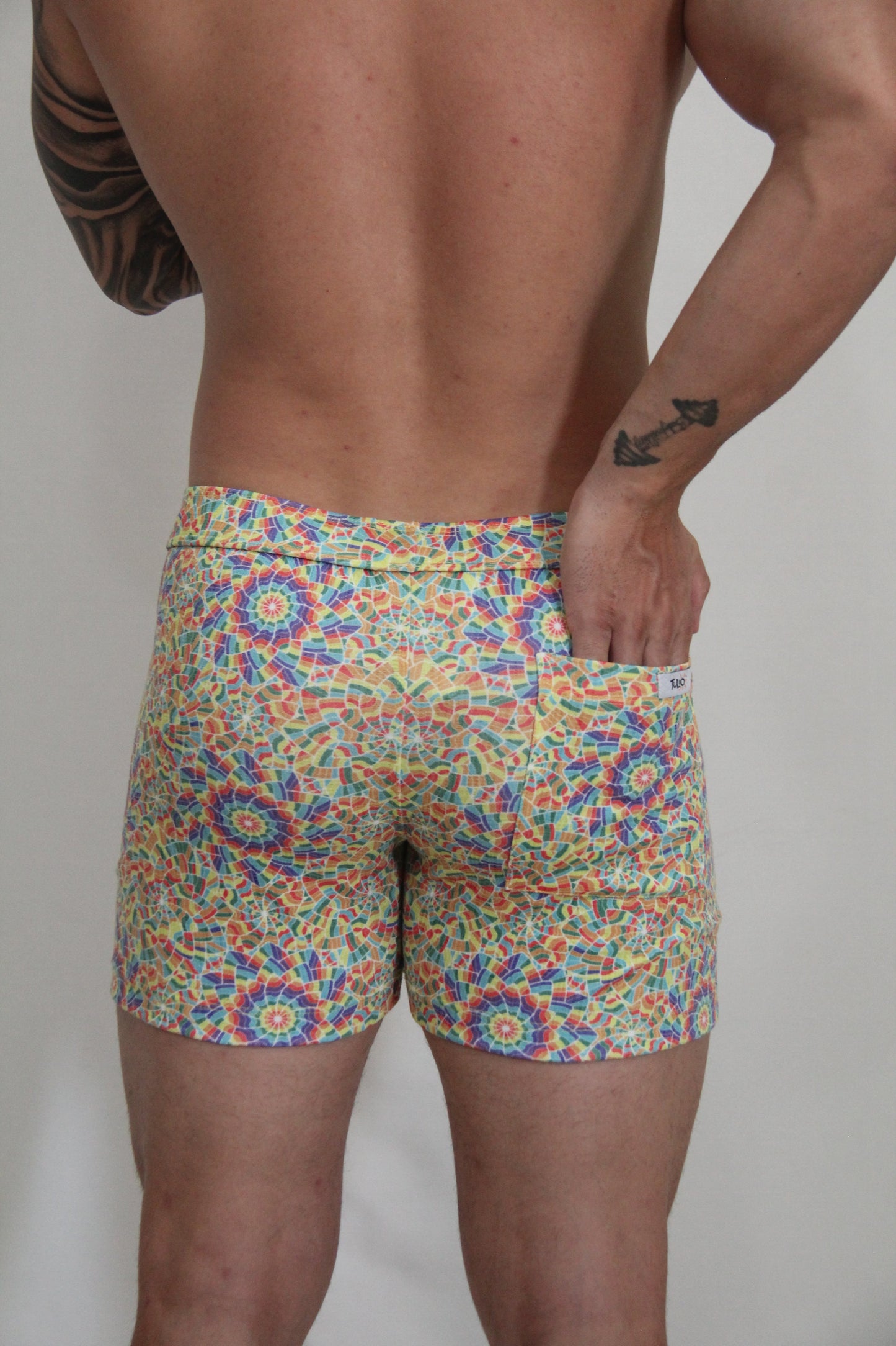 Rainbow kaleidoscope linen texture shorts featuring vibrant multicolored geometric mosaic patterned swim trunks