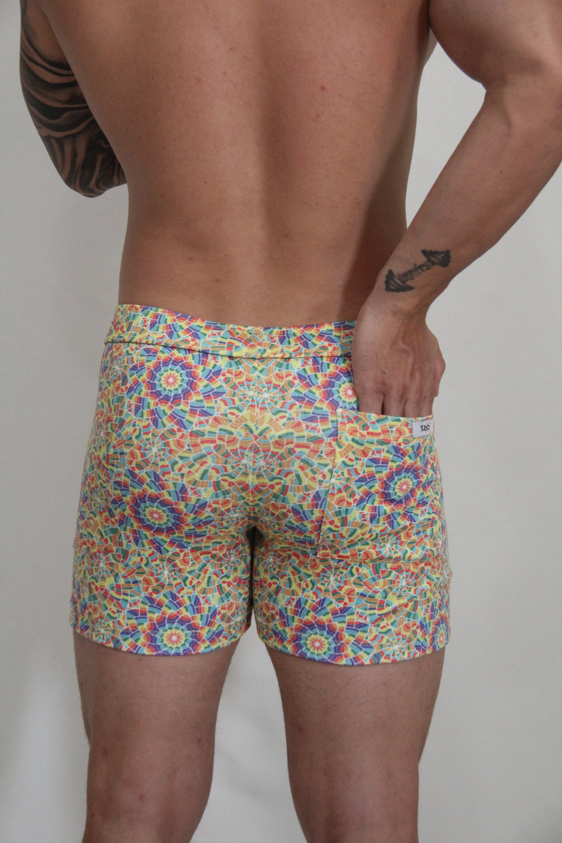 Rainbow kaleidoscope linen texture shorts featuring vibrant multicolored geometric mosaic patterned swim trunks