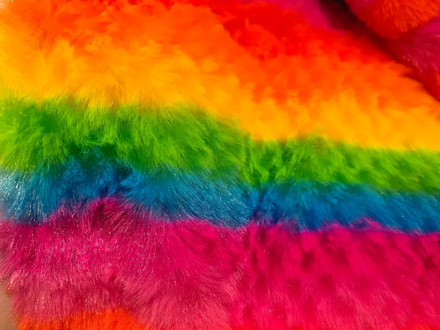 Rainbow stripe faux fur hoodie with vibrant red orange yellow green blue and pink fluffy fabric stripes