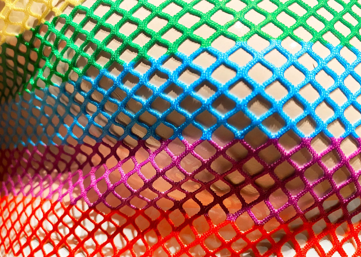 A rainbow stripe fine mesh tee featuring vibrant rainbow-colored diamond patterned mesh netting