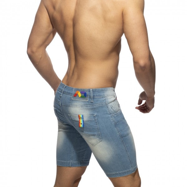 Back view of light-wash denim rainbow tape jean shorts with rainbow-colored patches on waistband and pocket