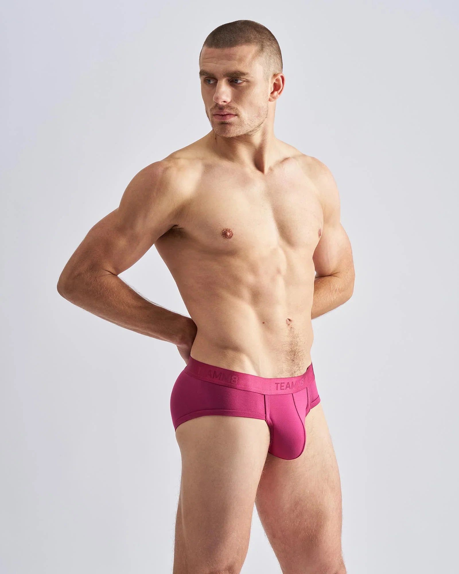 Magenta reign brief men’s form-fitting briefs with smooth fabric waistband featuring team brand logo