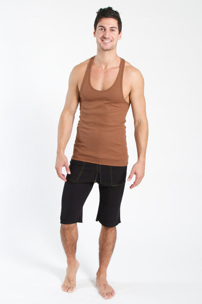 A man wearing a chocolate racer-back yoga tank with a scoop neckline and black shorts in a fitted style
