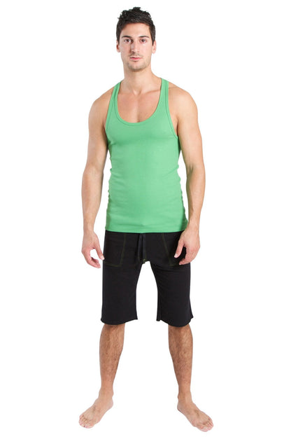 A man wearing a bamboo green racerback yoga tank top with a rounded neckline and black shorts with side pockets