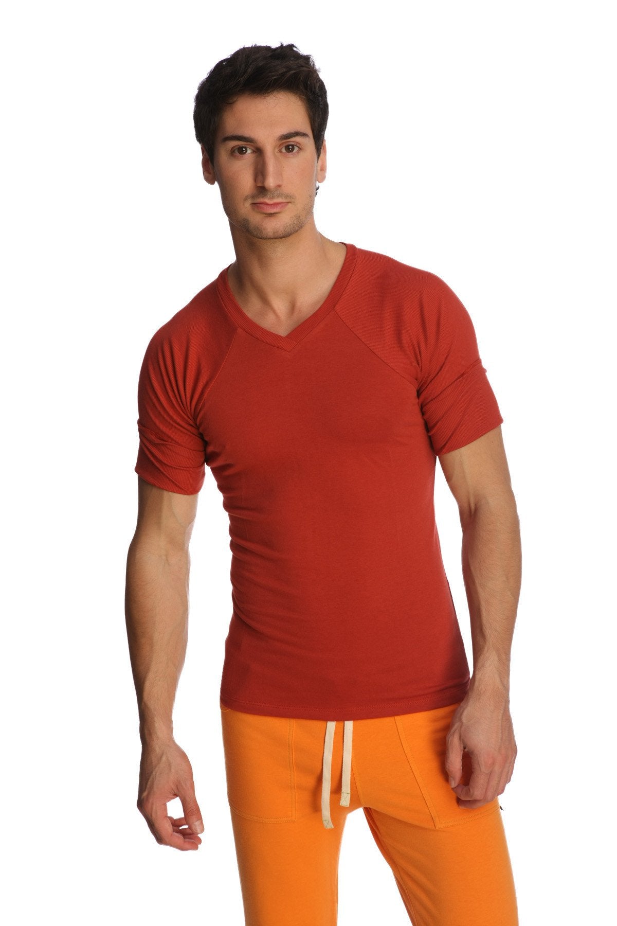 A man wearing a vibrant cinnabar red raglan virtual crew neck t-shirt with subtle seam detailing