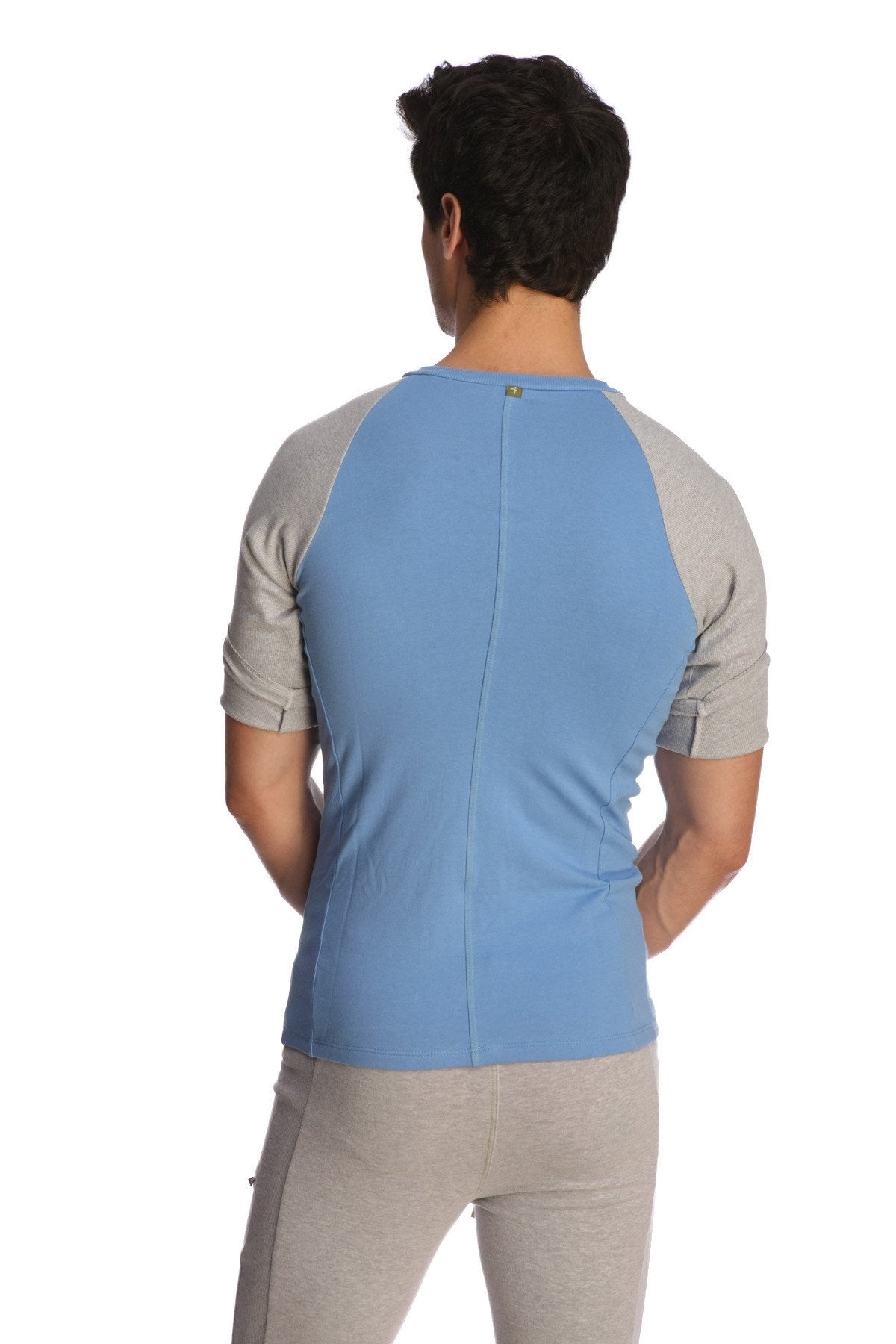 Back view of light blue and gray raglan virtual crew neck shirt with subtle vertical seam for athletic wear