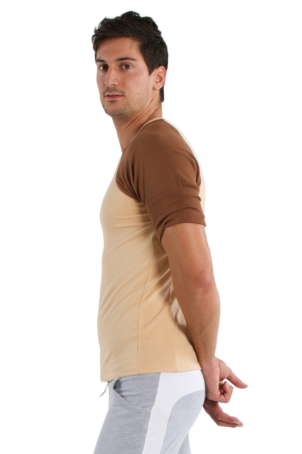 A man wearing a beige and brown two-tone raglan virtual crew neck t-shirt with rolled-up short sleeves