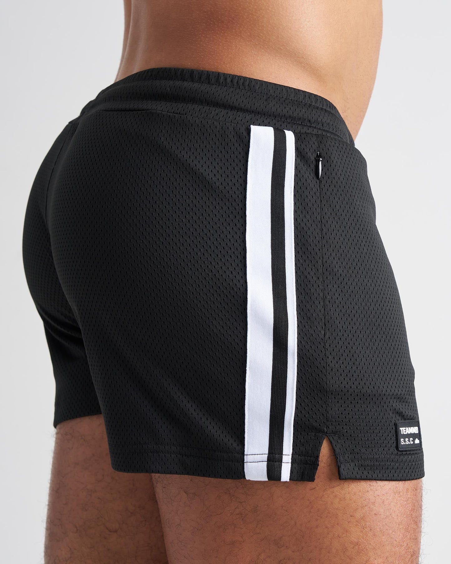 Black mesh athletic shorts with two white side stripes and a small brand tag on the lower right leg for s s c fraternity 3 inch mesh short
