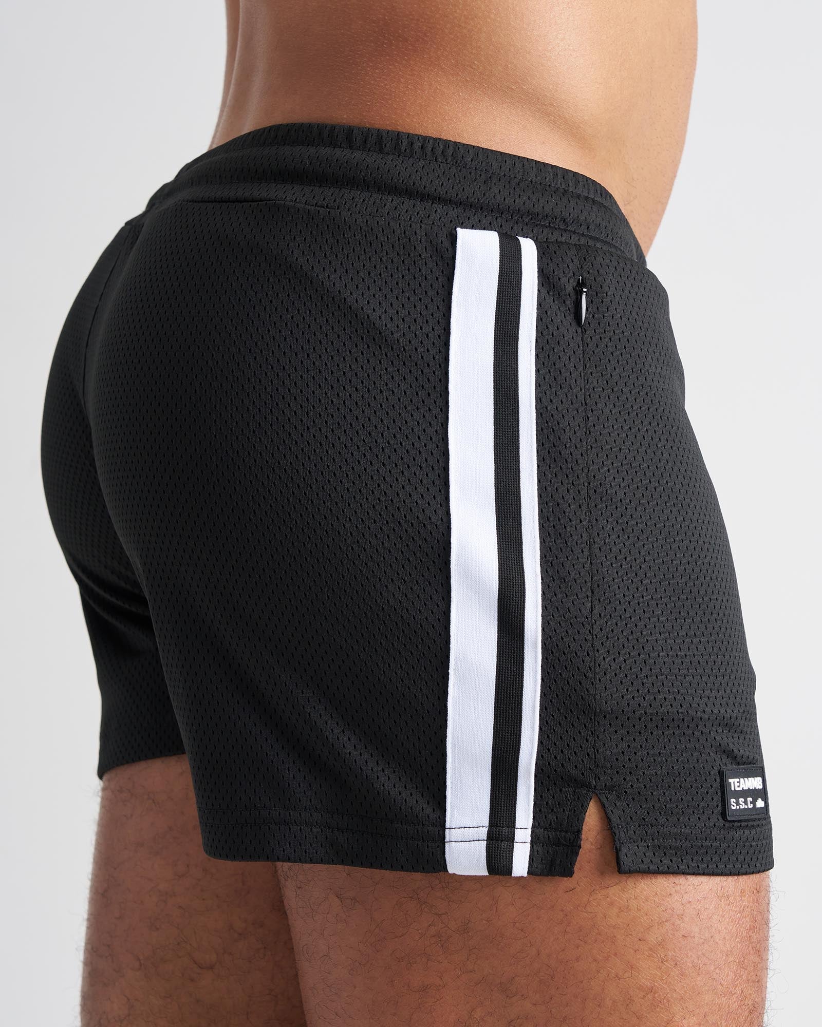 Black mesh athletic shorts with two white side stripes and a small brand tag on the lower right leg for s s c fraternity 3 inch mesh short
