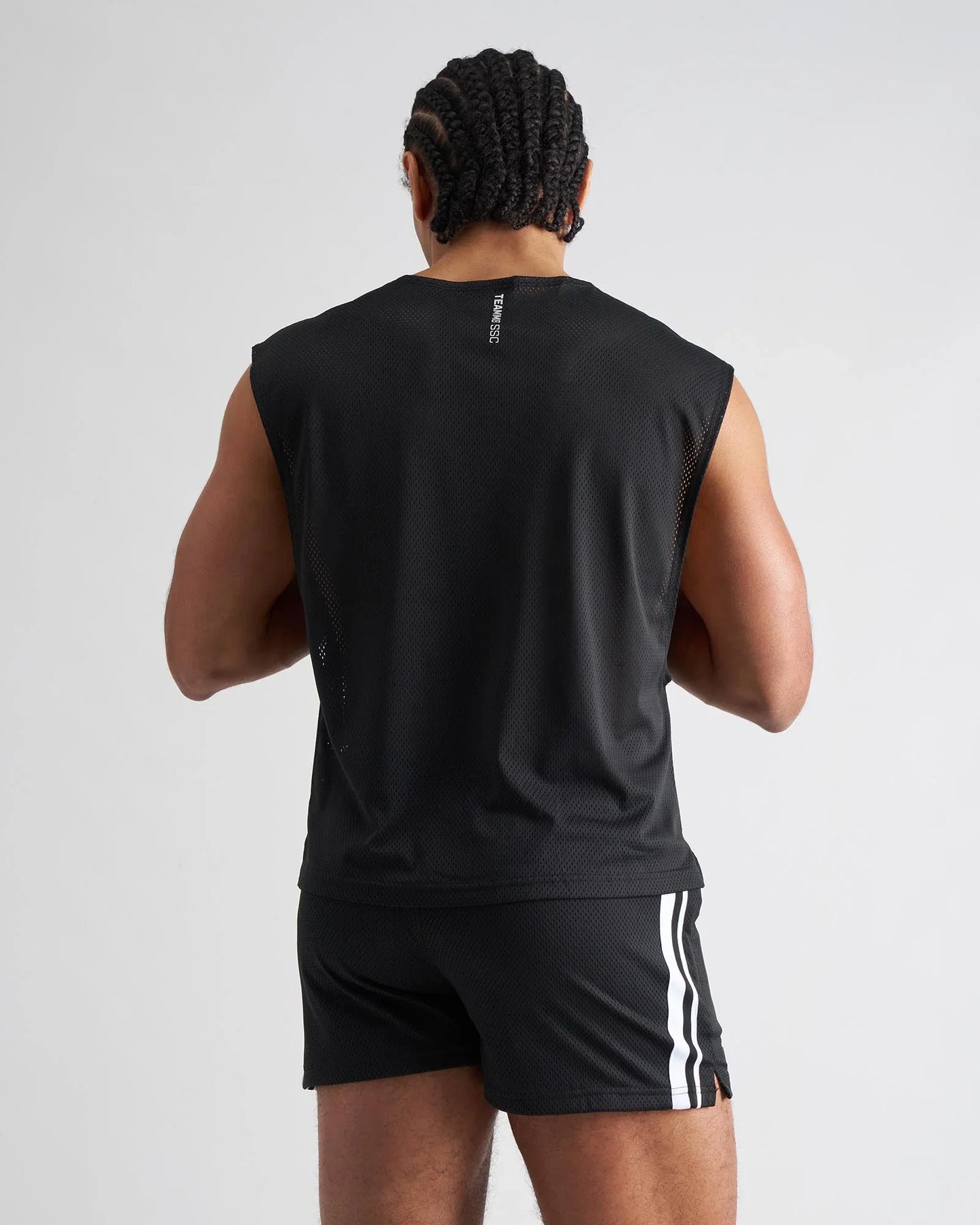 Black mesh sleeveless s.s.c. mesh muscle tank showing back with subtle vertical logo on breathable athletic top