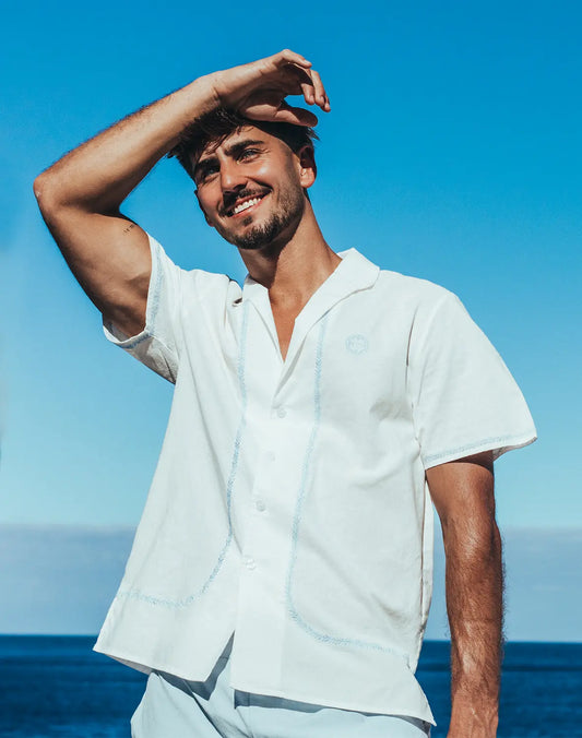White santorini linen shirt with short sleeves light blue embroidery and small circular logo on left chest