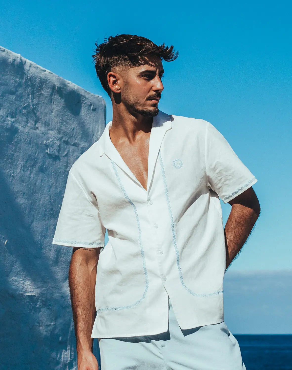 White santorini linen shirt with light blue stitching details and short sleeves in button-up style
