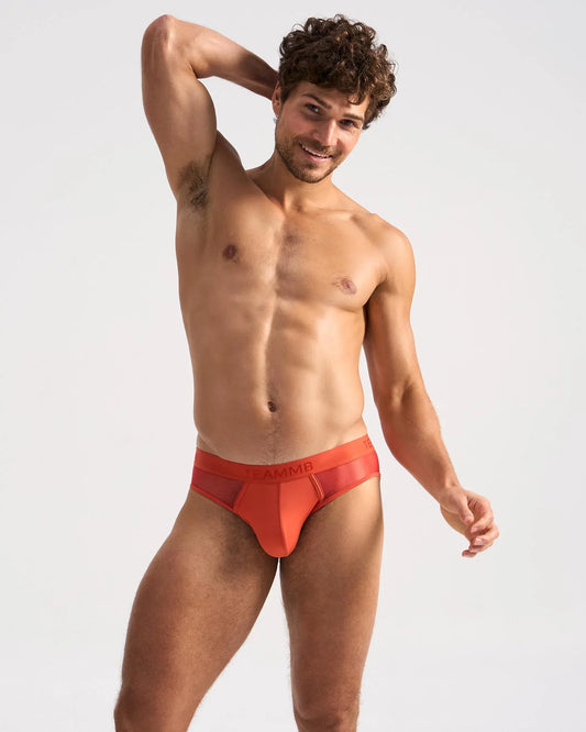 Bright orange score sheer brief with solid waistband featuring the amm logo made of sheer mesh fabric