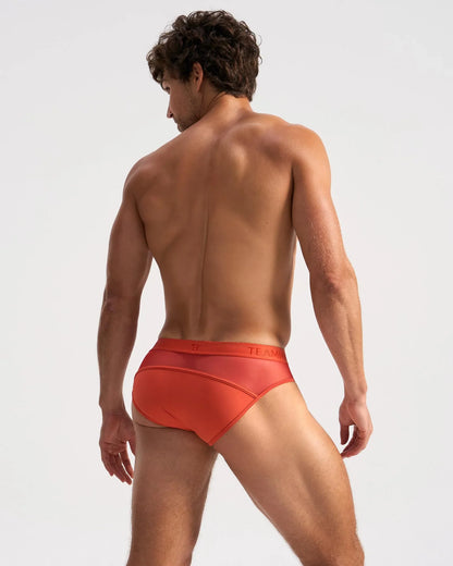 Orange men’s score sheer brief with subtle textured pattern and team brand name printed on the waistband