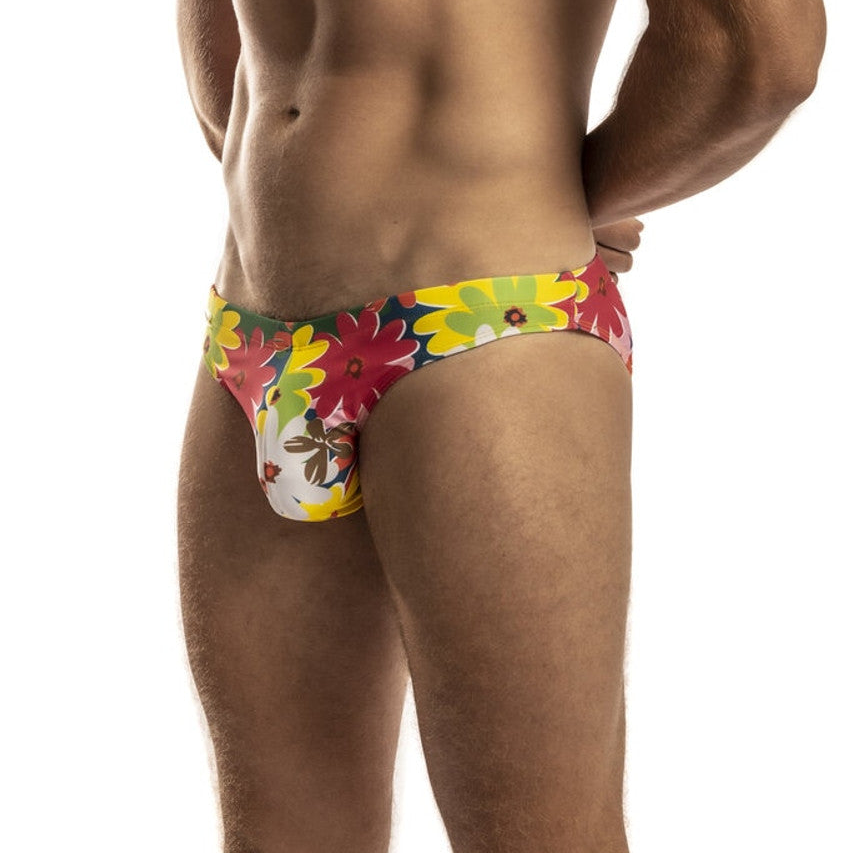 Vibrant floral-patterned second skin swimsuit men’s swim trunks in bold red yellow and green hues with playful design