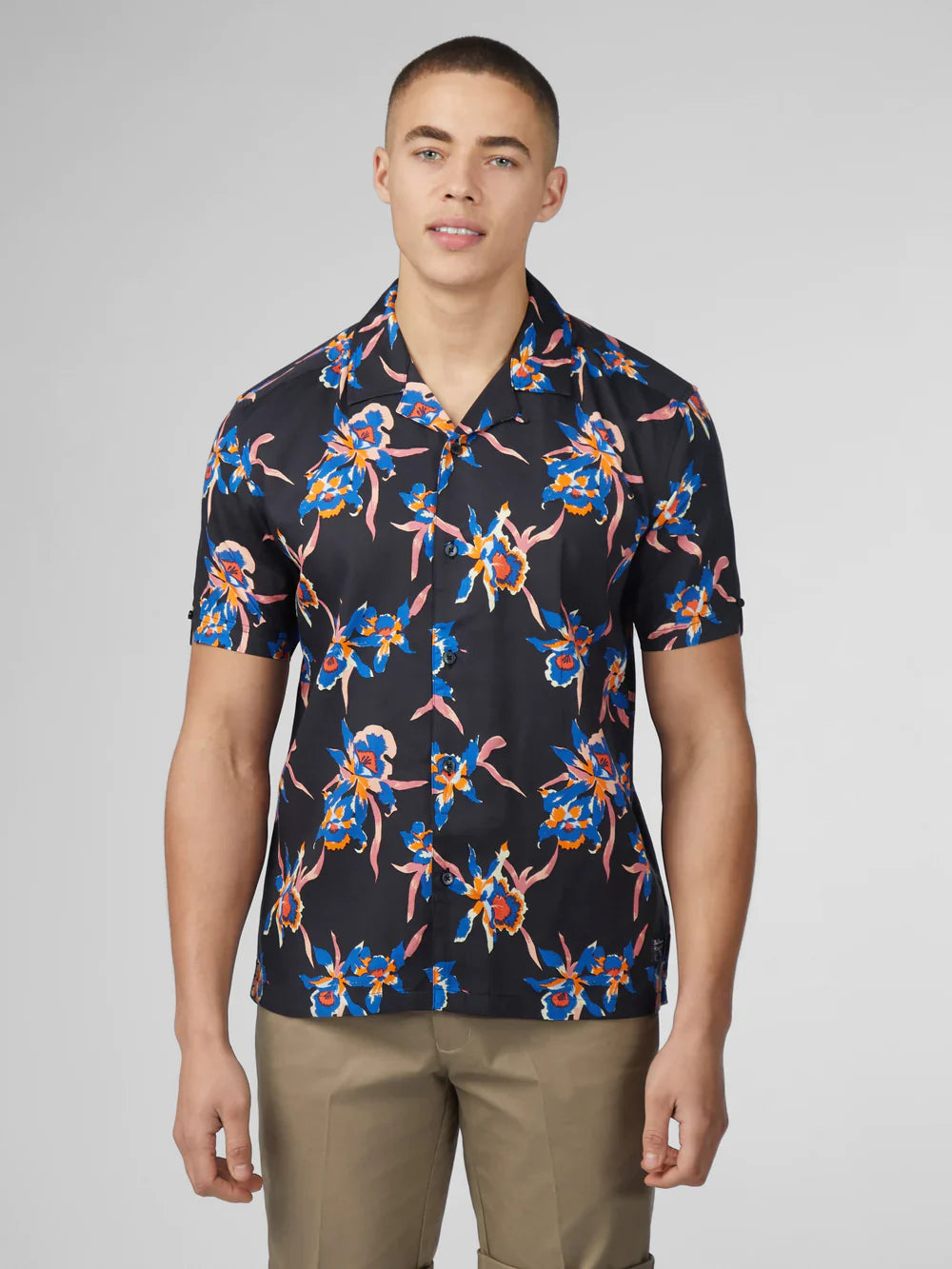 Black short-sleeved button-up shirt with vibrant blue pink and orange orchid floral pattern signature botanical print