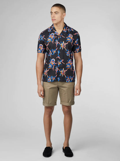 Black short-sleeved button-up shirt with signature botanical print in blue pink and orange floral pattern
