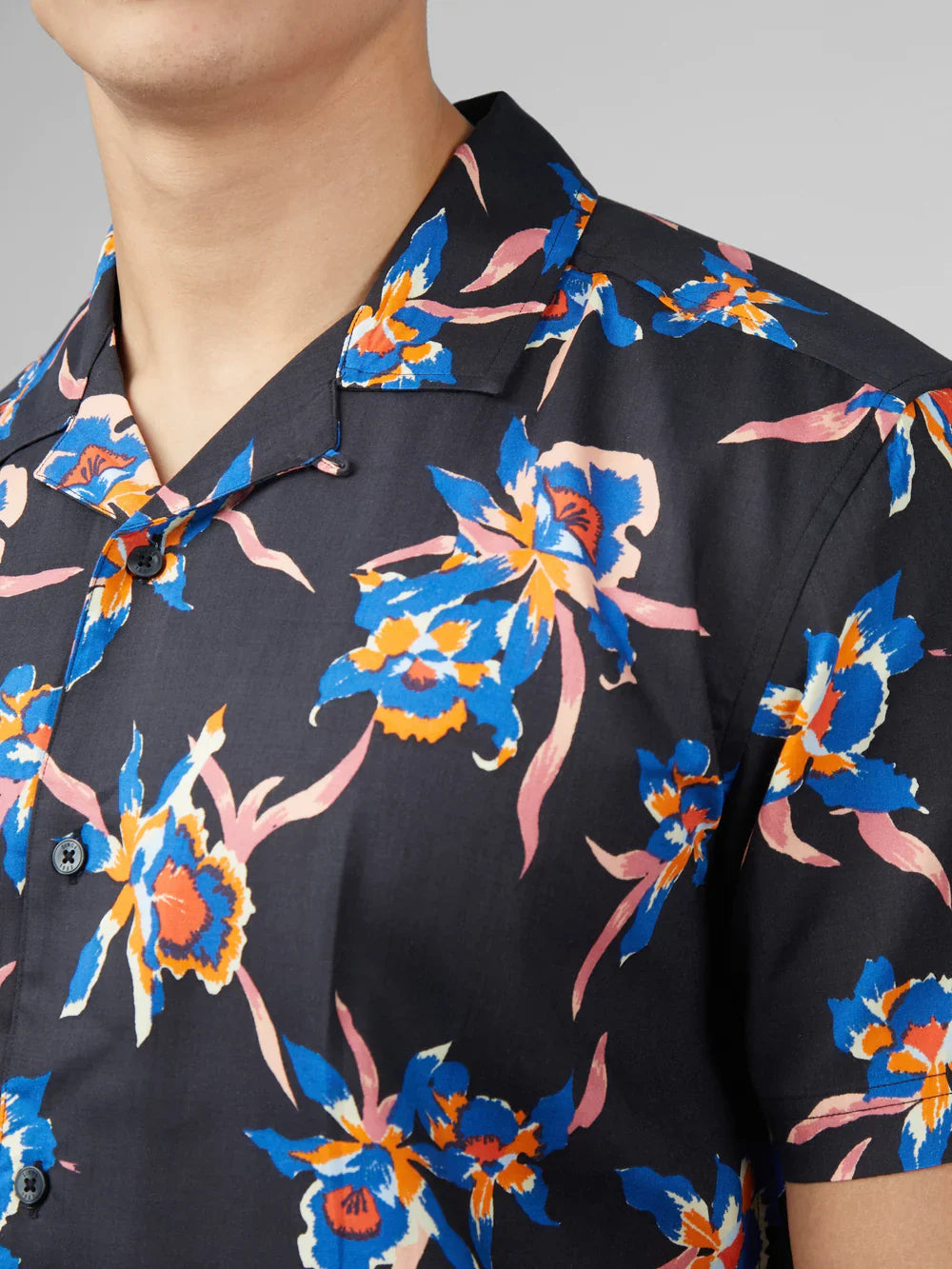 Black short-sleeved button-up shirt with vibrant blue orange and pink orchid floral pattern signature botanical print