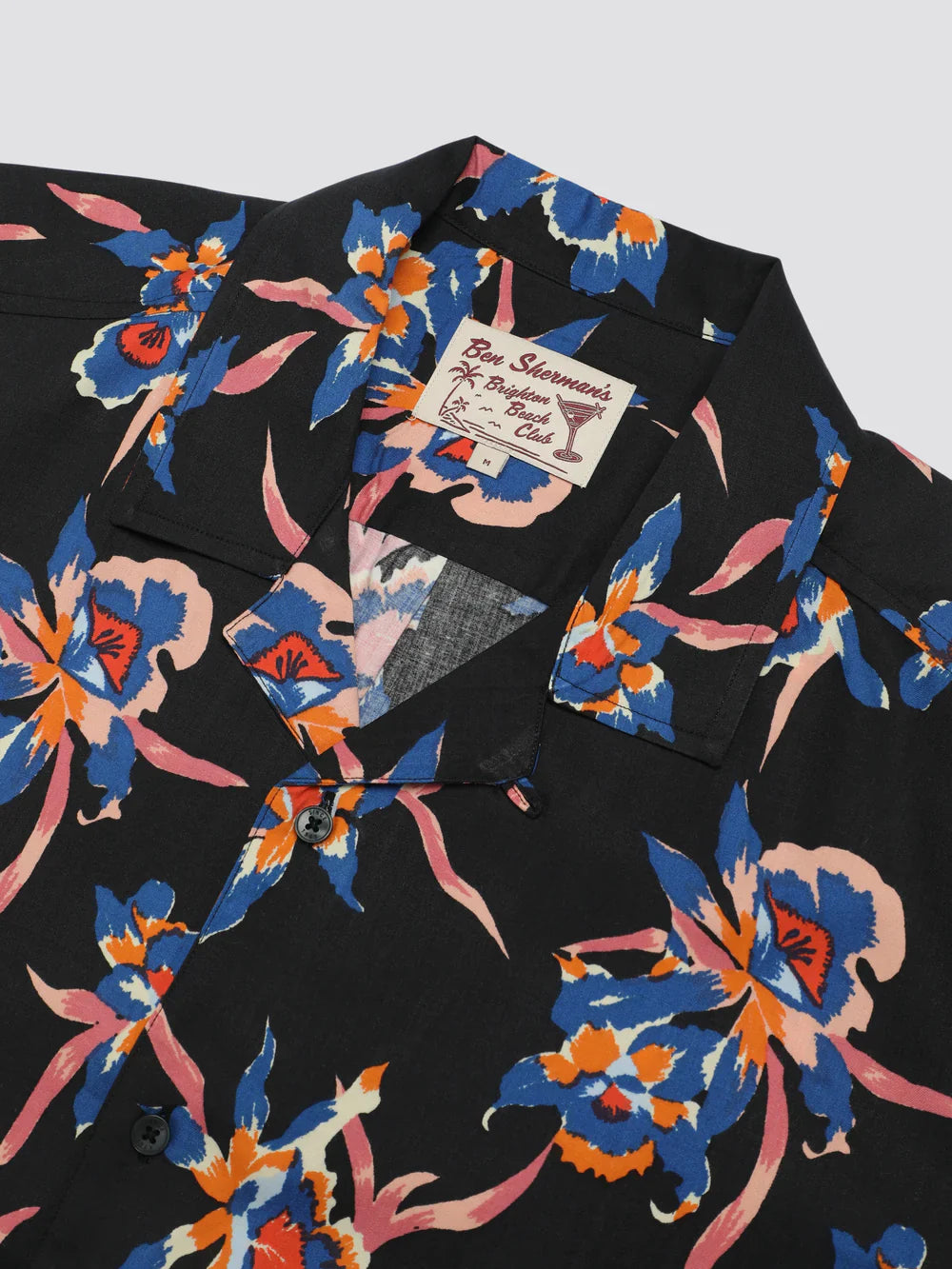 Black button-up shirt with signature botanical print featuring vibrant blue orange and pink floral pattern